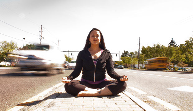 Monique Dauphin doing sukhasana in a busy street